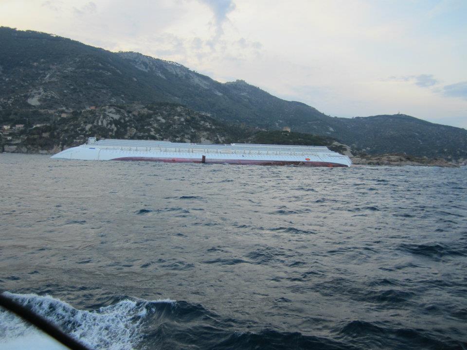 La Concordia completamente capovolta al tramonto